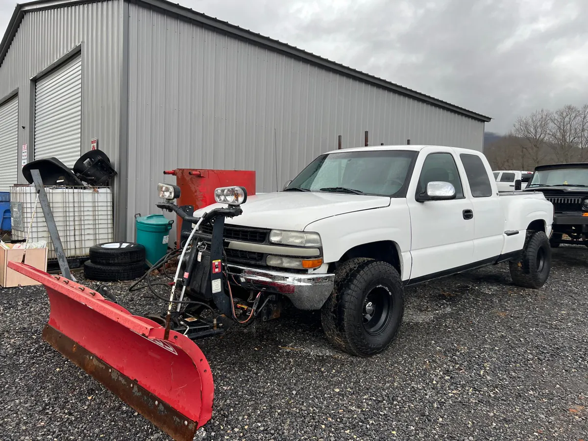 A snowplow pickup parked outside the McElroy Auto Repair shop